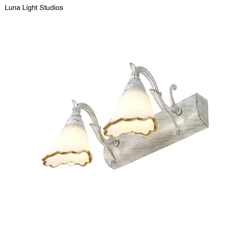 White glass vanity light with two scalloped shades on weathered backplate by Decorbites on Tampa Home & Garden Store