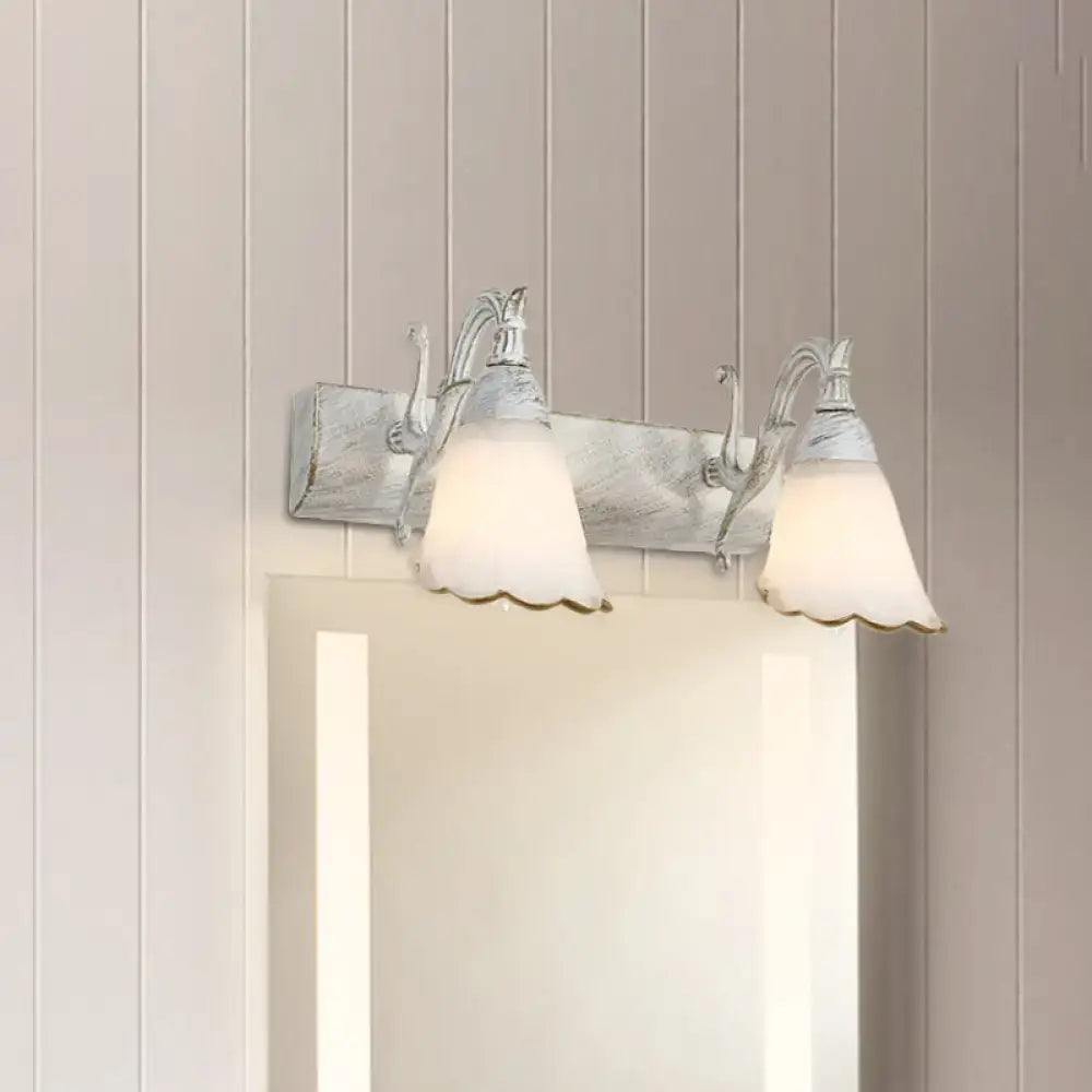 Decorbites two-light white glass vanity fixture with scalloped shades and distressed backplate on Tampa Home & Garden Store