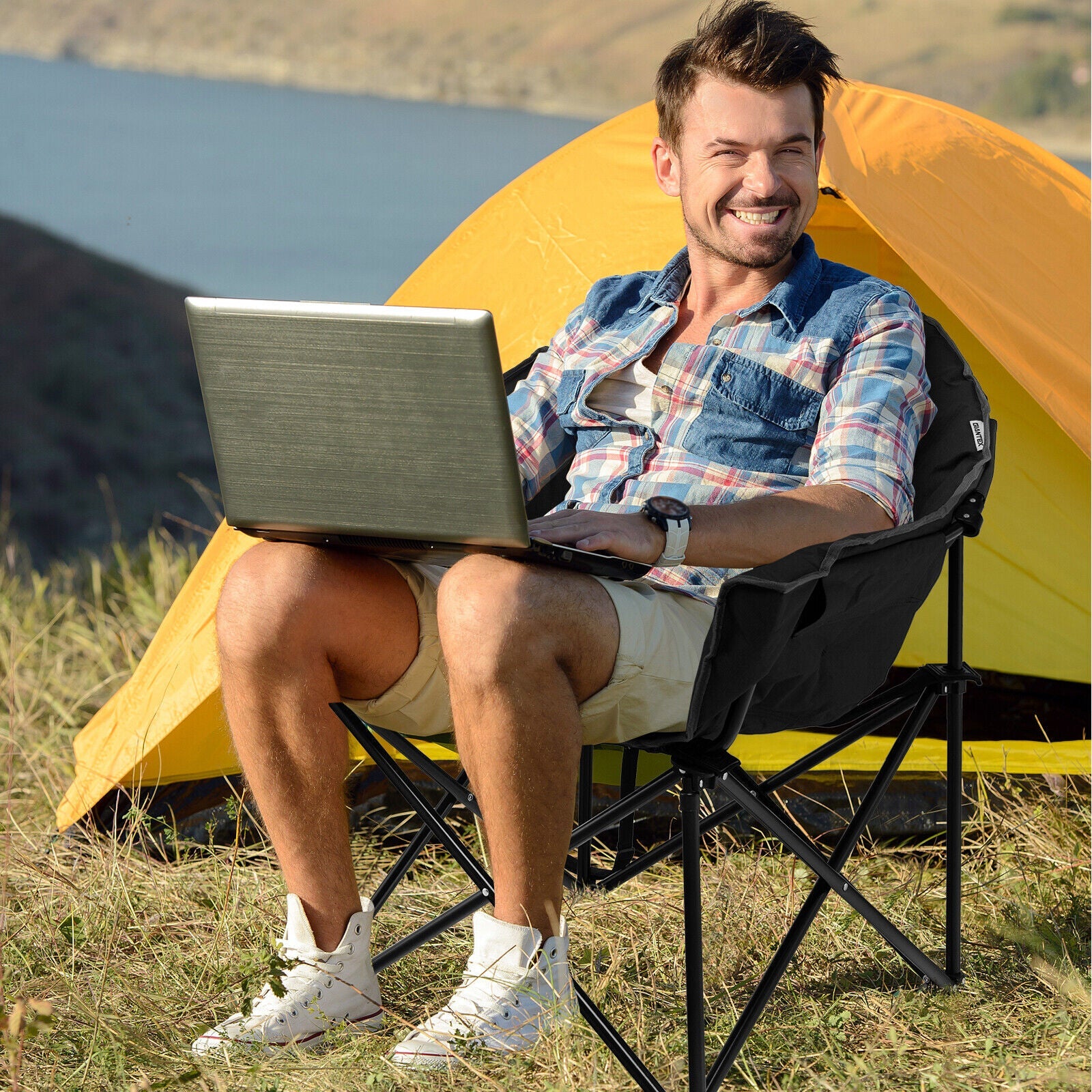 Folding Camping Moon Padded Chair GemGear black frame with carrying bag outdoors beside a yellow tent on Tampa Home & Garden Store