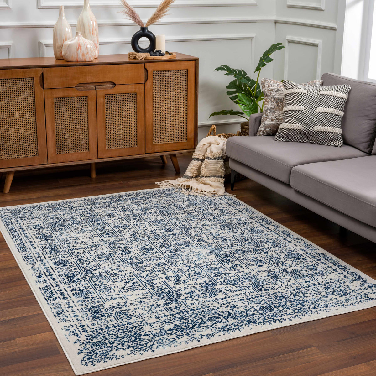Michie Blue Area Rug by Boutique Rugs, blue and white patterned rug in living room with gray sectional on Tampa Home & Garden Store