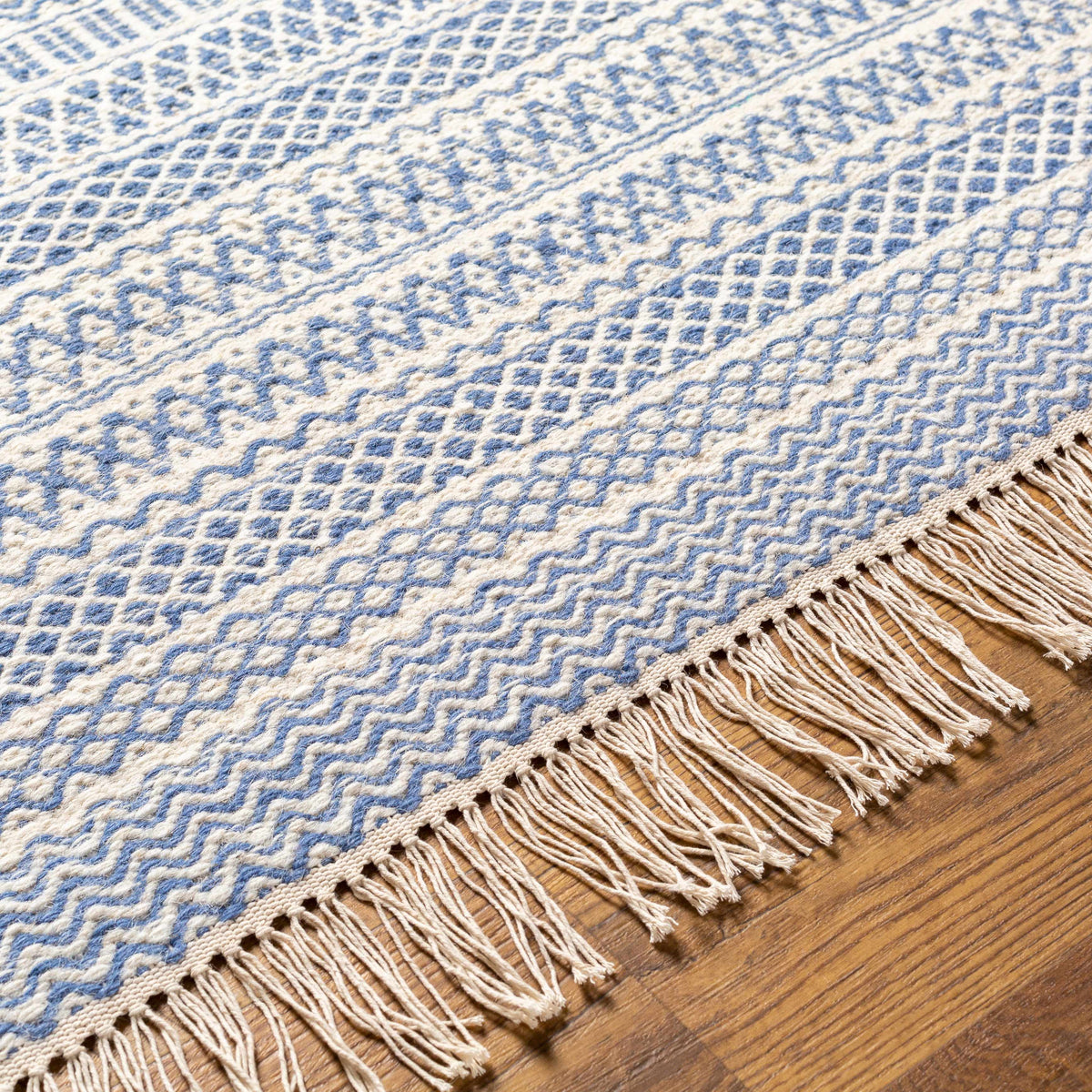 Sanc Blue/Cream Flatweave Wool Rug blue cream geometric pattern with fringed edge on wood floor on Tampa Home & Garden Store