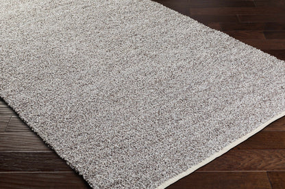Kamil Gray Solid Area Rug from Boutique Rugs, plush gray shag on dark hardwood floor on Tampa Home & Garden Store