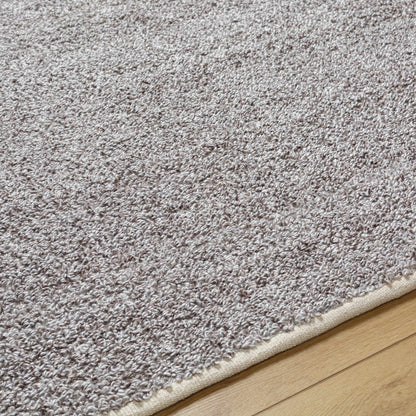 Kamil Gray Solid Area Rug by Boutique Rugs, gray shag with beige binding on wood floor on Tampa Home & Garden Store