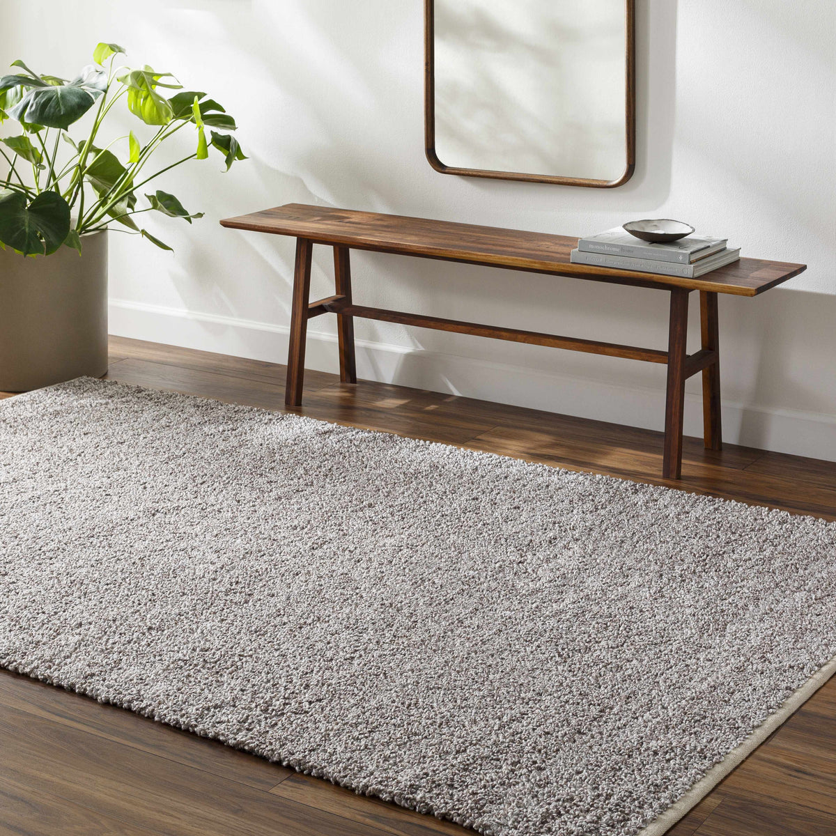 Kamil Gray Solid Area Rug by Boutique Rugs on a warm wood floor in a stylish living space on Tampa Home & Garden Store