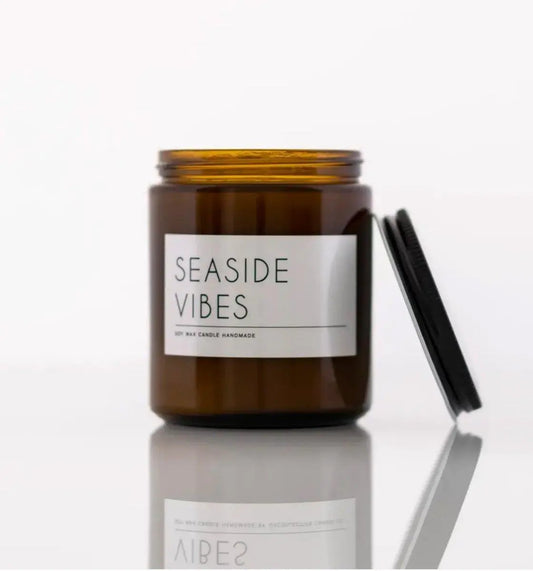 Candle Seaside Vibes in amber glass jar with black lid; driftwood and sea salt scent on Tampa Home & Garden Store