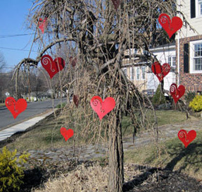 Hanging Heart Tree Ornaments (Set of 12) by Rustica Ornamentals in bright red on a bare tree on Tampa Home & Garden Store