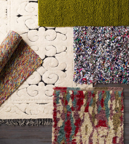 Frederika solid olive green wool shag rug by Boutique Rugs among several rug samples on Tampa Home & Garden Store