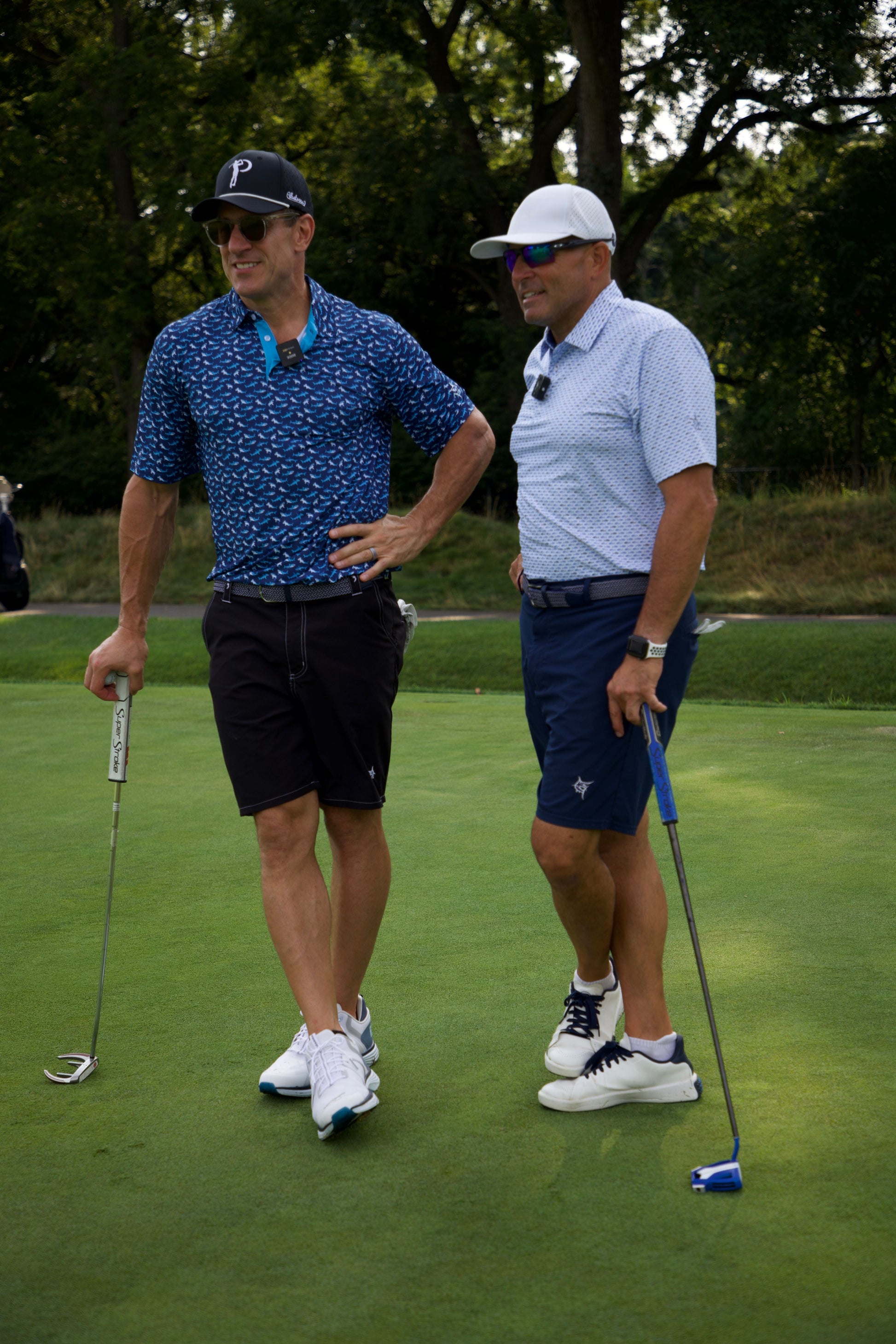 Sharks Polo by White Water Life, navy blue shark-print polo worn by golfer on a green course on Tampa Home & Garden Store