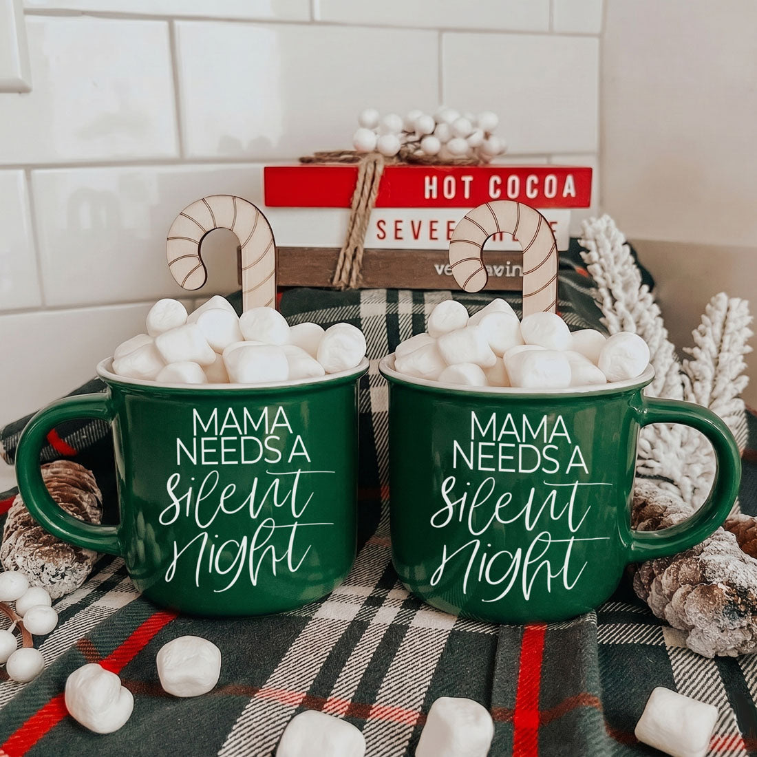 Two green Gia Roma Mama Silent Night mugs filled with marshmallows and candy canes on plaid backdrop on Tampa Home & Garden Store