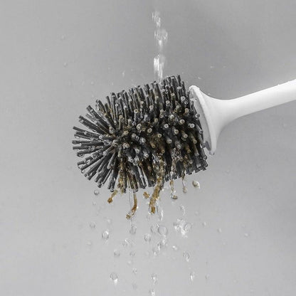 White-handled silicone toilet brush with dark bristles under running water on Tampa Home & Garden Store