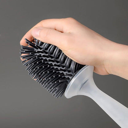 Stiff bristle toilet brush with black bristles and clear handle held in hand on Tampa Home & Garden Store