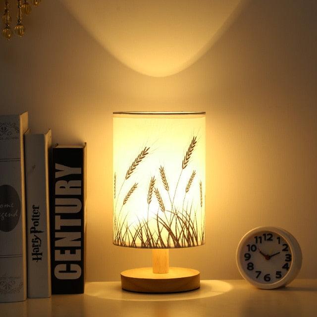 Stevvex Simple Modern Table Lamp solid wood base with warm glow beside 3 books and a clock on Tampa Home & Garden Store