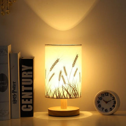 Stevvex Simple Modern Table Lamp solid wood base with warm glow beside 3 books and a clock on Tampa Home & Garden Store