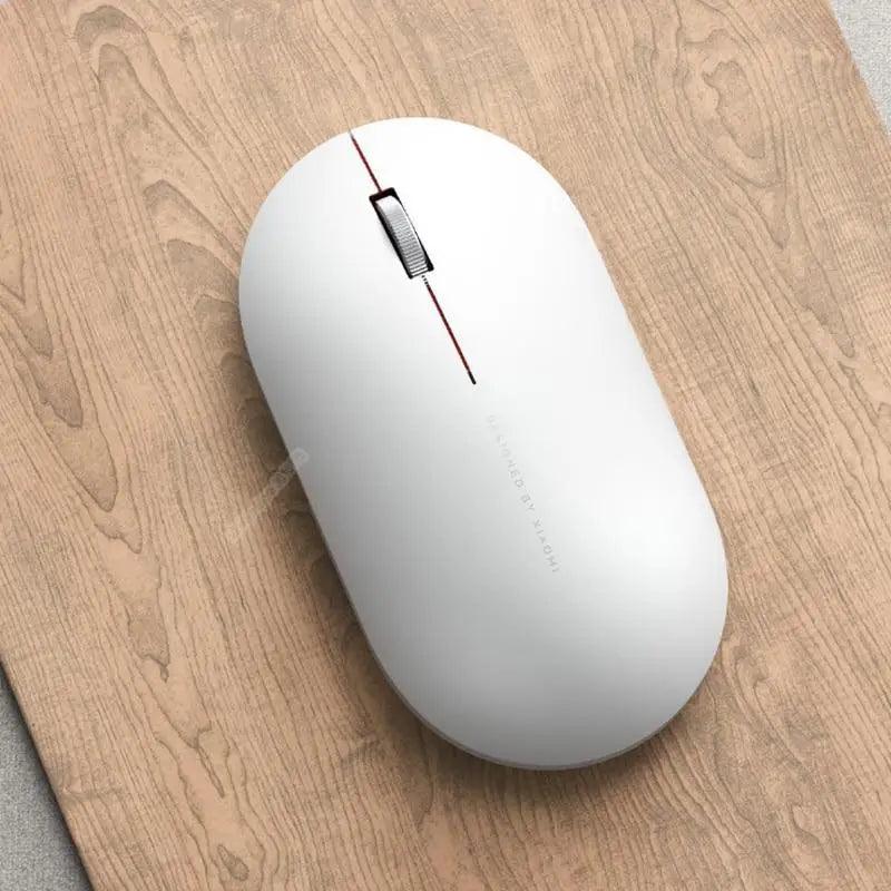 White wireless optical mouse with red stripe, slim USB/Bluetooth design on wood desk on Tampa Home & Garden Store