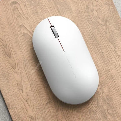 White wireless optical mouse with red stripe, slim USB/Bluetooth design on wood desk on Tampa Home & Garden Store