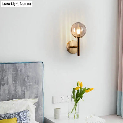 Amber glass wall sconce with round globe shade and brass hardware by Decorbites on Tampa Home & Garden Store