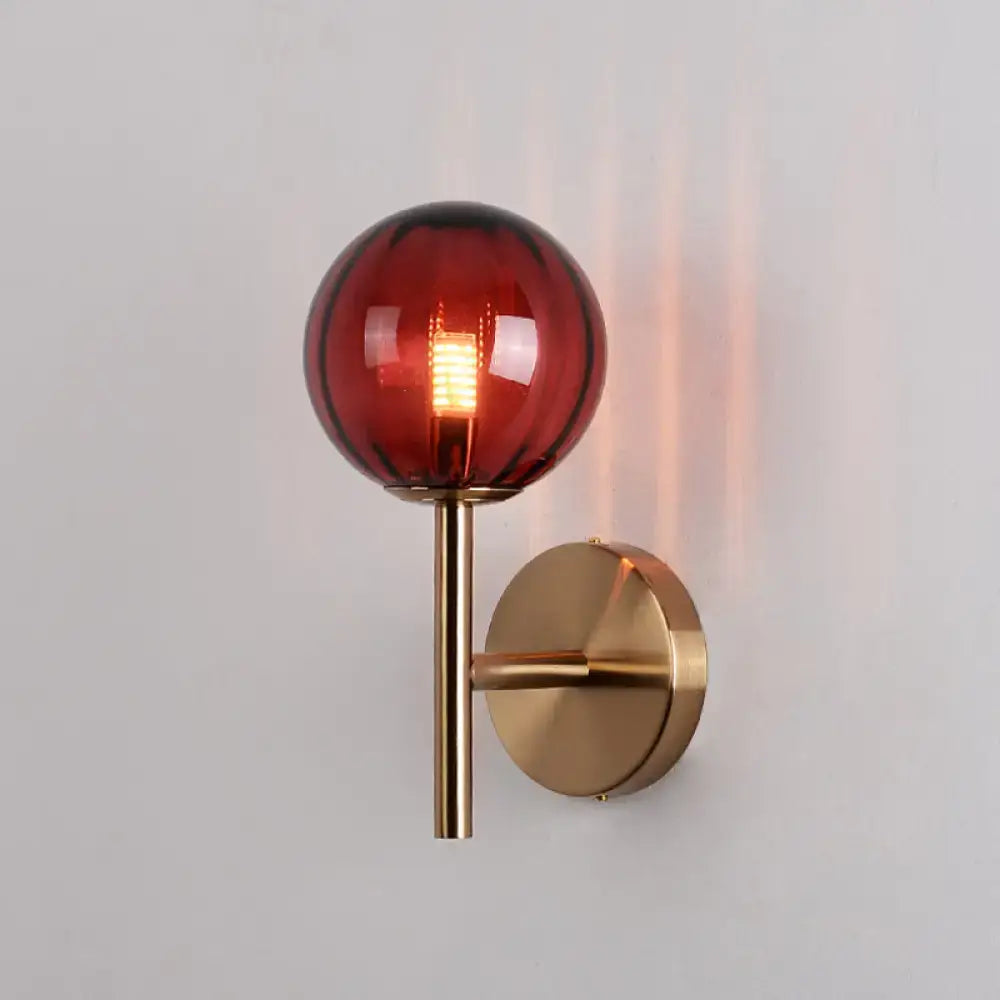 Amber red glass wall sconce with brass finish and round globe on wall mount on Tampa Home & Garden Store