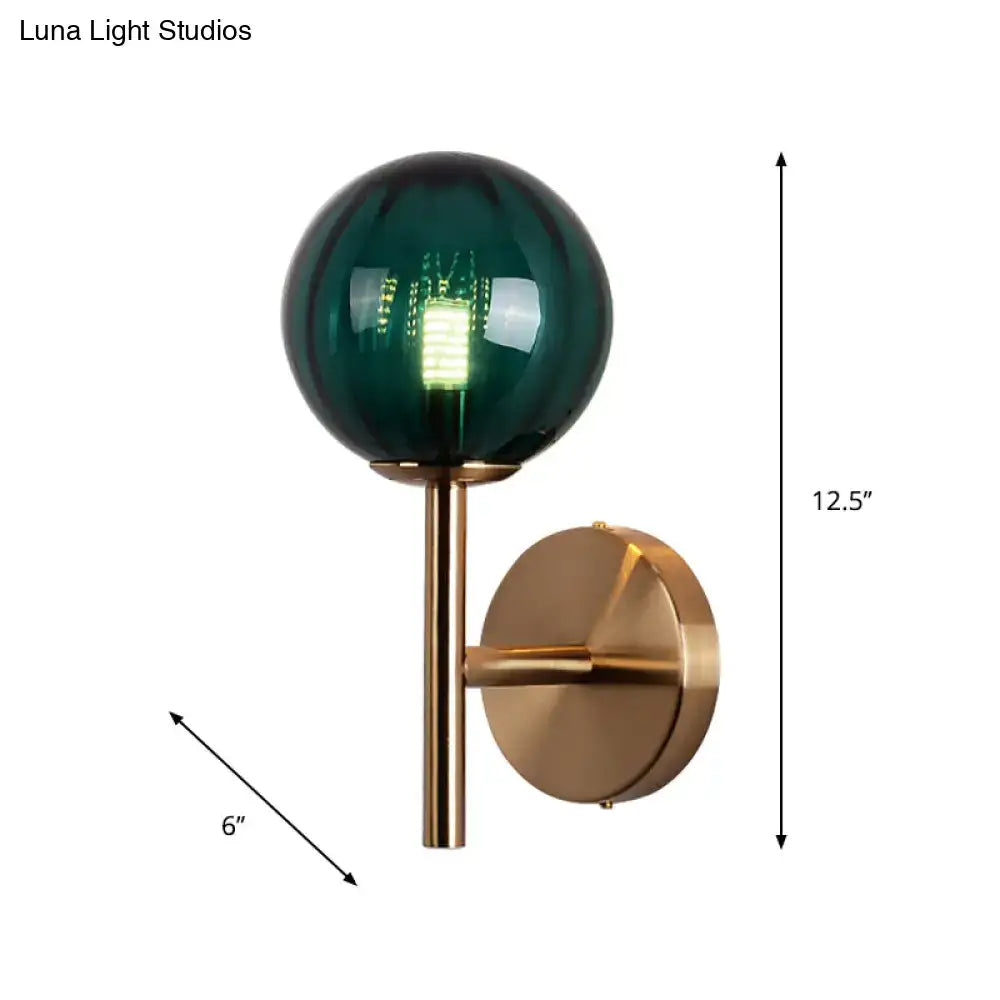 Green glass wall sconce with brass mount and globe on Tampa Home & Garden Store