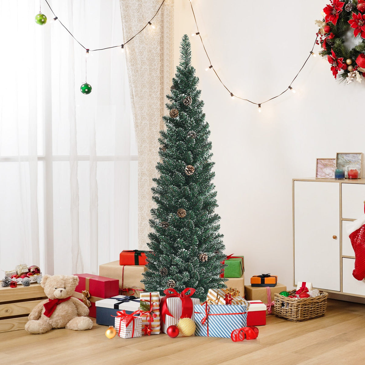 DirectDeals Snowy artificial pencil Christmas tree with pine cones in a gift-filled room on Tampa Home & Garden Store