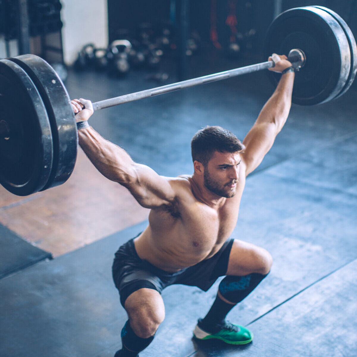 1000 lbs Weight Lifting Barbell with black steel plates lifted overhead by a muscular athlete in a gym on Tampa Home & Garden Store