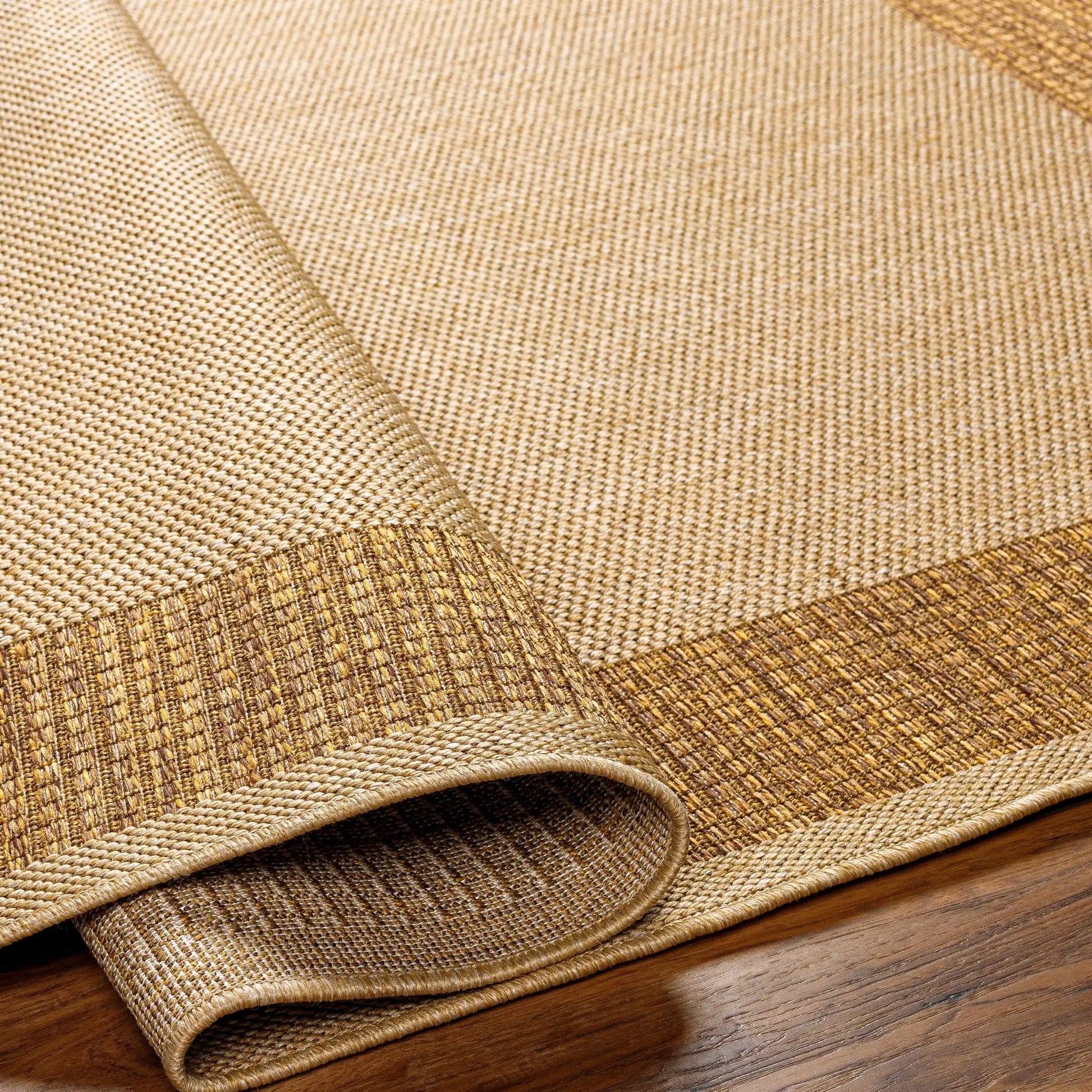 Inigo Flatweave Faux Jute Outdoor Rug natural beige; rolled and stacked (3) on Tampa Home & Garden Store