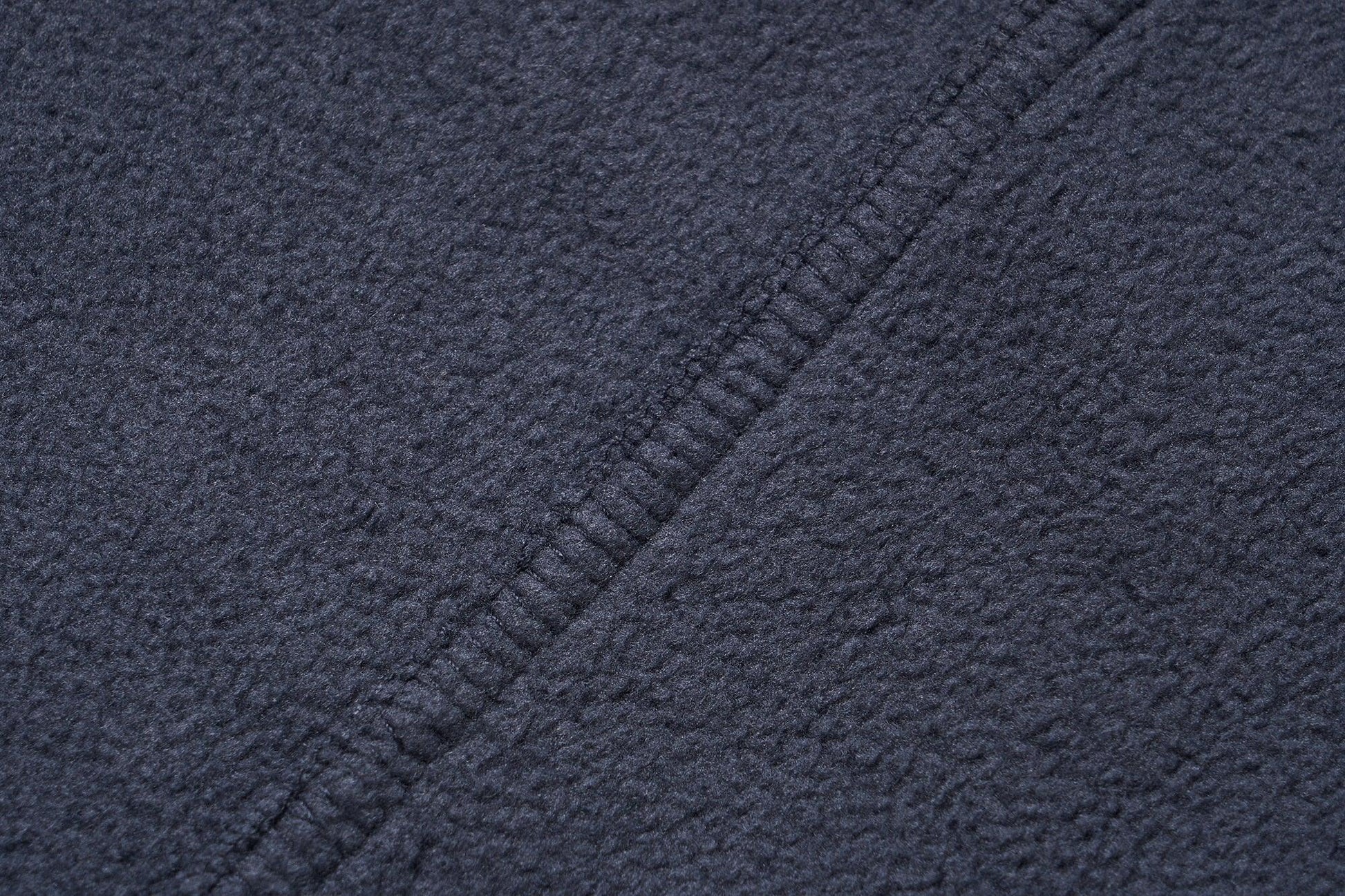 Stevvex navy fleece jacket fabric close-up with textured weave and diagonal seam on Tampa Home & Garden Store