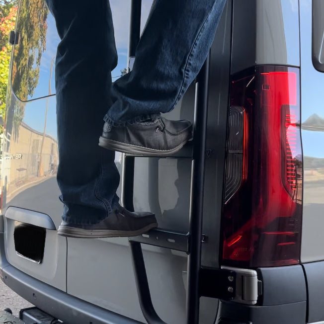 Sprinter Van Rear Ladder rear-mounted on gray van; avatar offroad, person in jeans climbing on Tampa Home & Garden Store