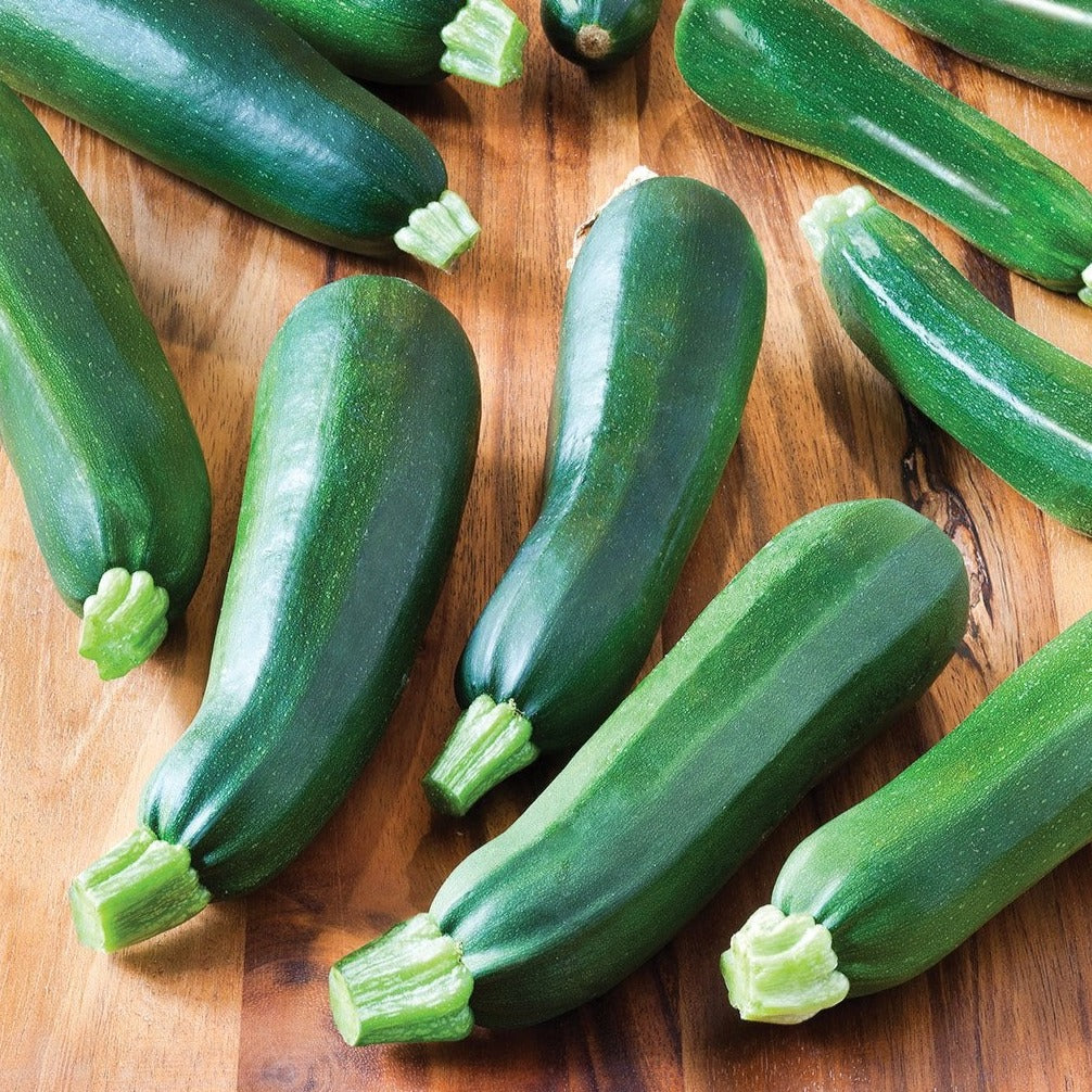 Zucchini Black Beauty seeds by Seedtime Store, green zucchinis arranged on a wooden board on Tampa Home & Garden Store