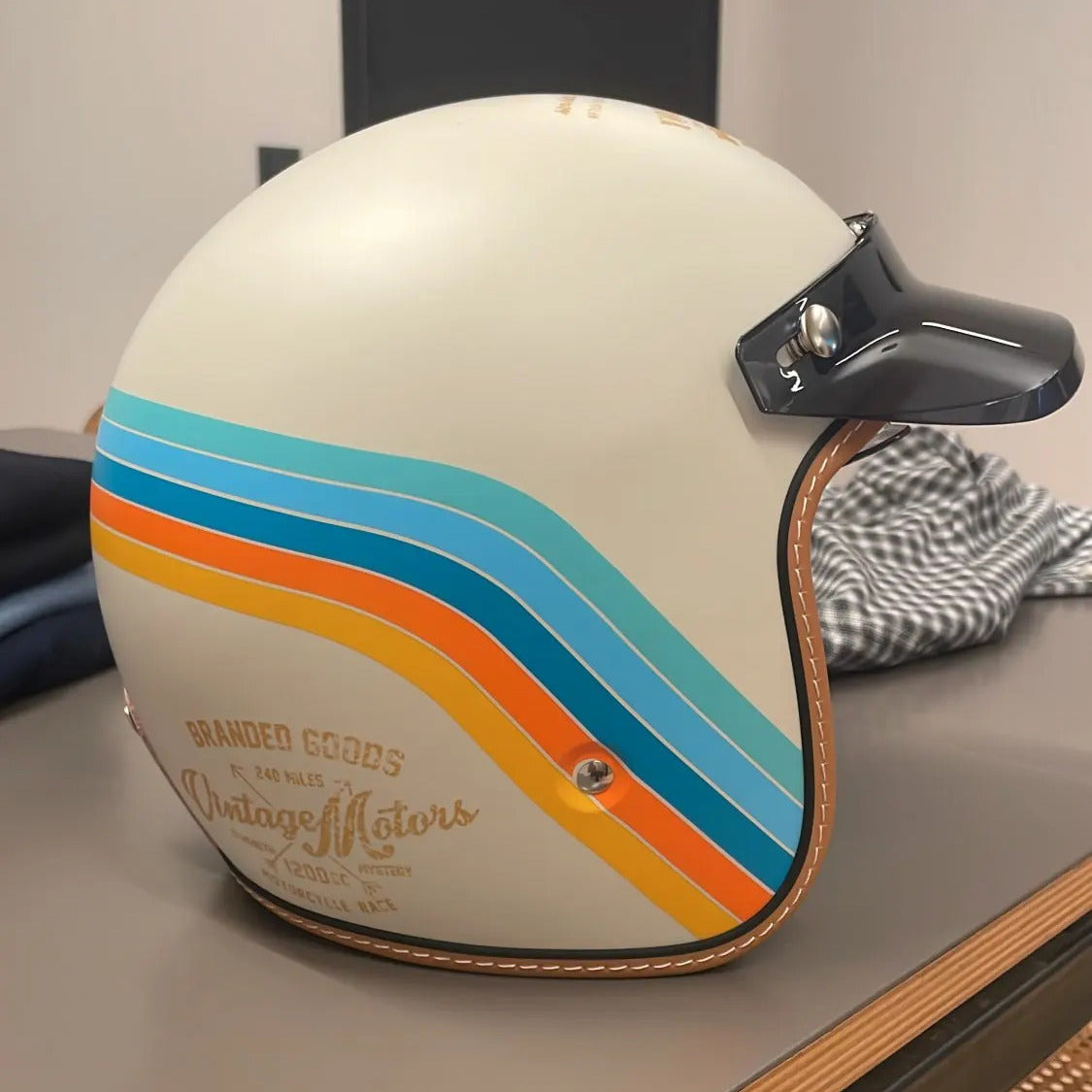 The Street King helmet by BikerZoneZ, cream shell with orange teal blue stripes, dark visor on Tampa Home & Garden Store