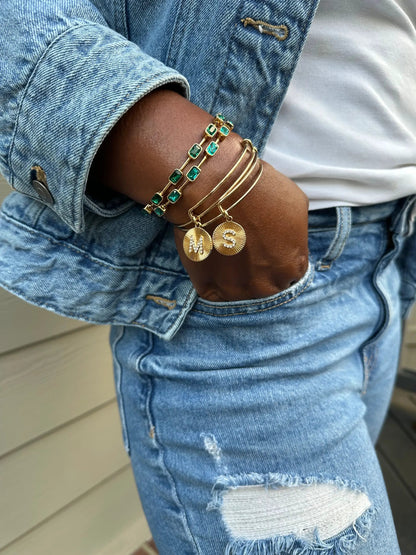 Alex and Ani Emerald Cut Birthstone Bangle with emerald stones on gold links MS charms on denim on Tampa Home & Garden Store