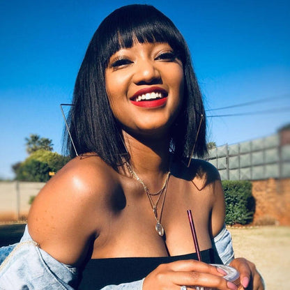 Straight Bob Wig Stevvex, black human-hair short bob with bangs worn by a smiling woman outdoors on Tampa Home & Garden Store