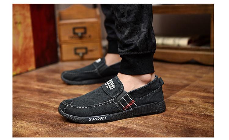 Stevvex men's black canvas slip-on shoes with white stitching and rubber sole on wooden floor on Tampa Home & Garden Store