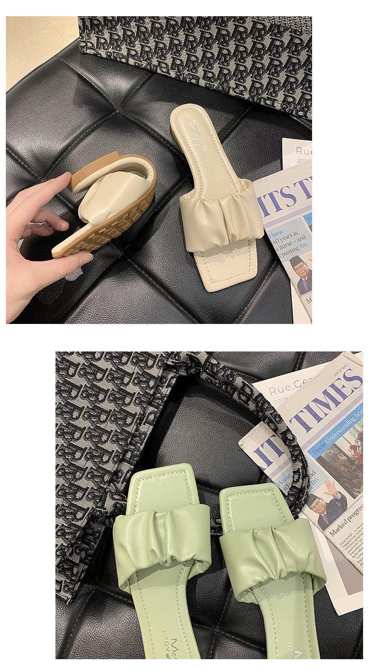 Beige ruched open-toe flat sandals and mint-green bow-strap sandals, two pairs on a black surface on Tampa Home & Garden Store