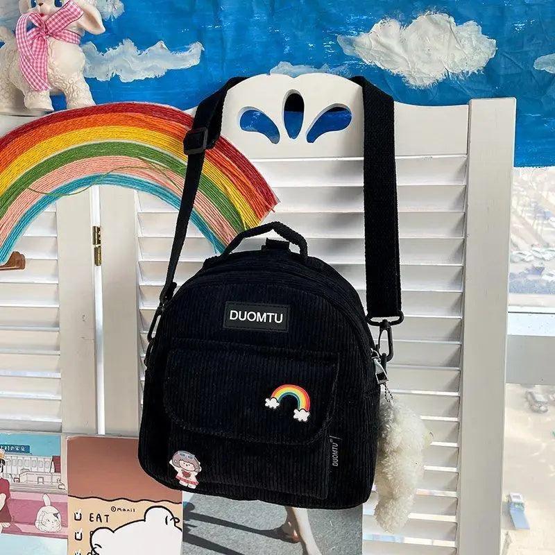 Mini black corduroy backpack by Duomtu with rainbow patch and fluffy keychain on Tampa Home & Garden Store