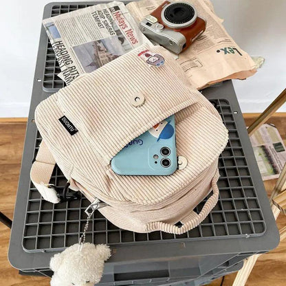 Stevvex small beige corduroy backpack with front pocket, top flap button, and fluffy pompom charm on Tampa Home & Garden Store
