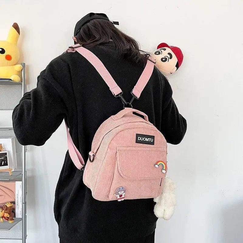 Backpack pink corduroy with front pocket and rainbow patch, DUOMTU label, worn by a person on Tampa Home & Garden Store