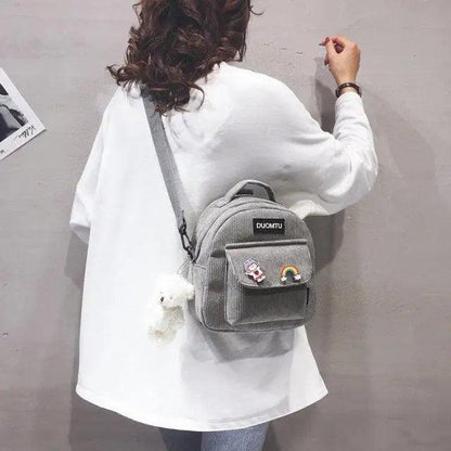 Stevvex gray small backpack with front zip pocket and patches worn by model in white top on Tampa Home & Garden Store
