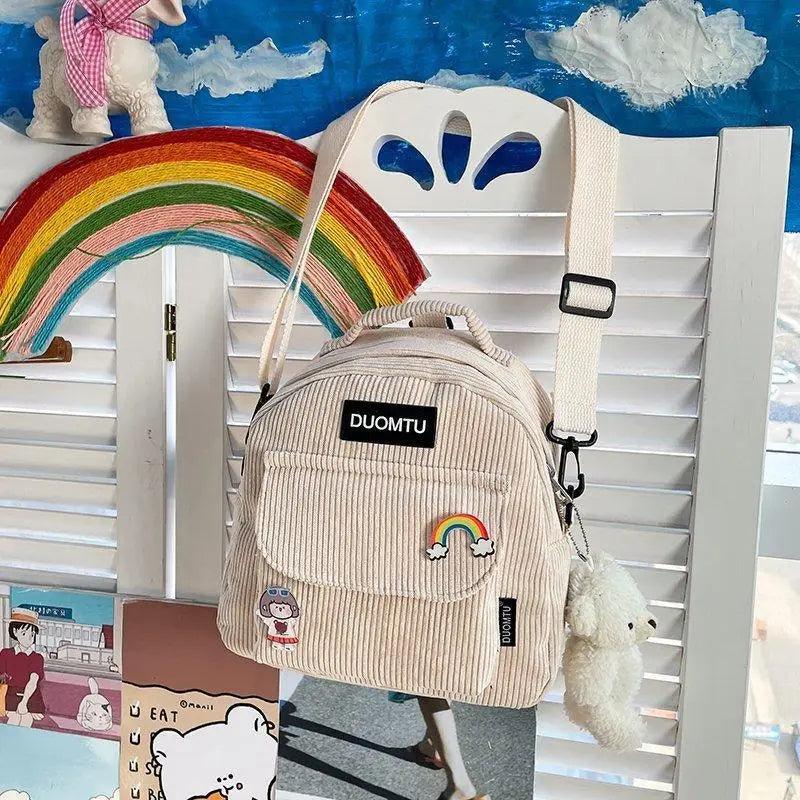 Small beige corduroy backpack with rainbow patch, DUOMTU, adjustable strap, plush keychain on Tampa Home & Garden Store