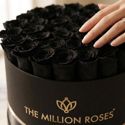 Supreme Black Box black roses arrangement by The Million Roses with a hand and diamond ring on Tampa Home & Garden Store
