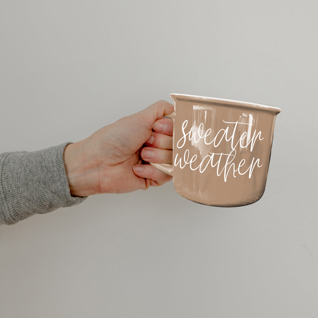 Gia Roma Sweater Weather coffee mug in beige ceramic with white script, hand-held on Tampa Home & Garden Store