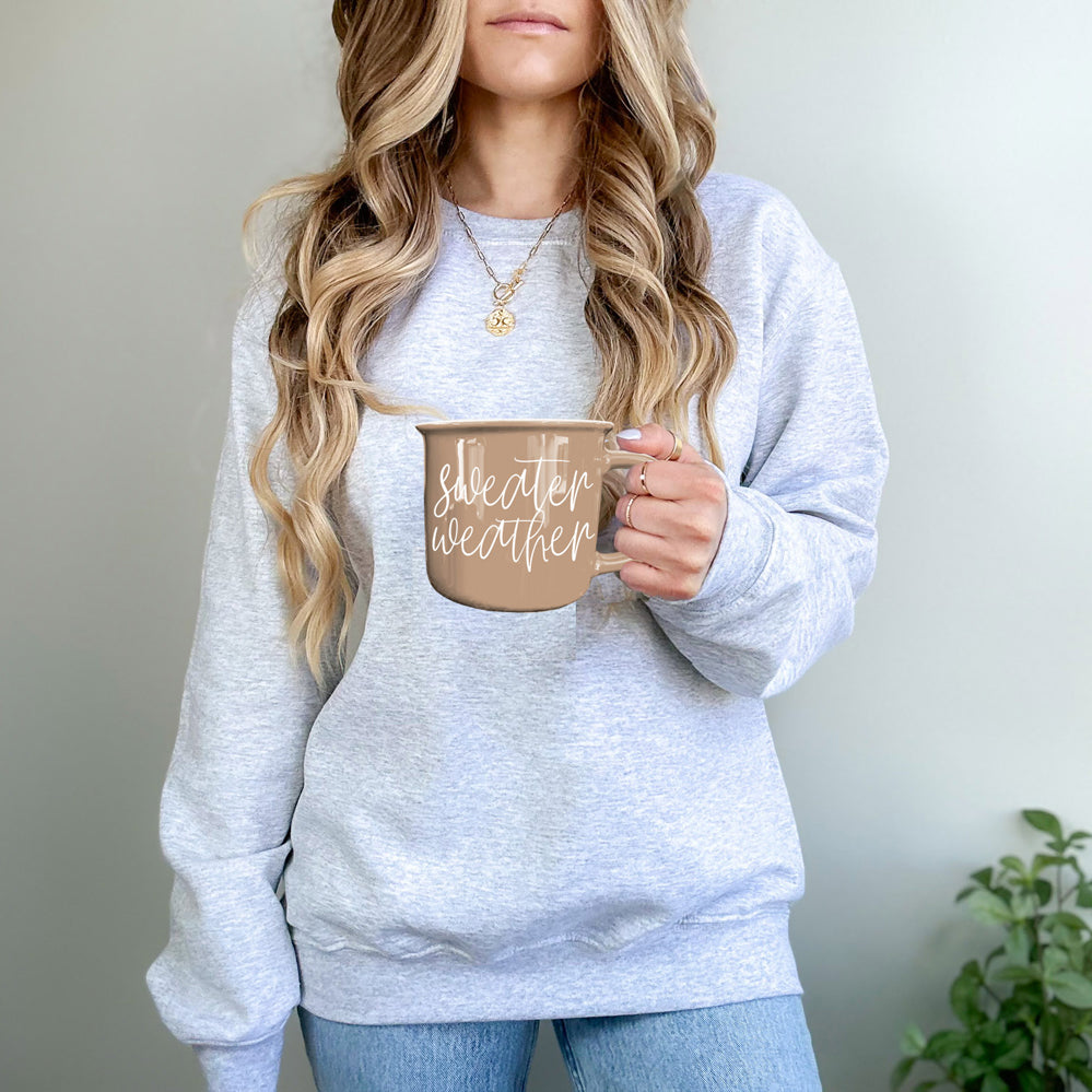 Gia Roma mug tan ceramic with sweater weather script held by woman in gray oversized sweater on Tampa Home & Garden Store