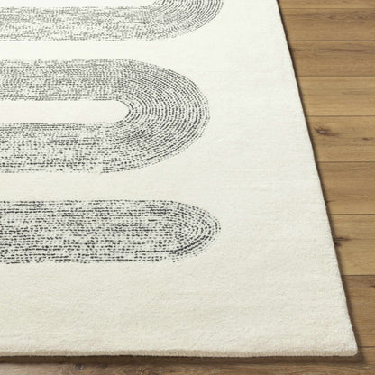 Saura Wool Area Rug cream with black curved ring pattern on wood floor on Tampa Home & Garden Store