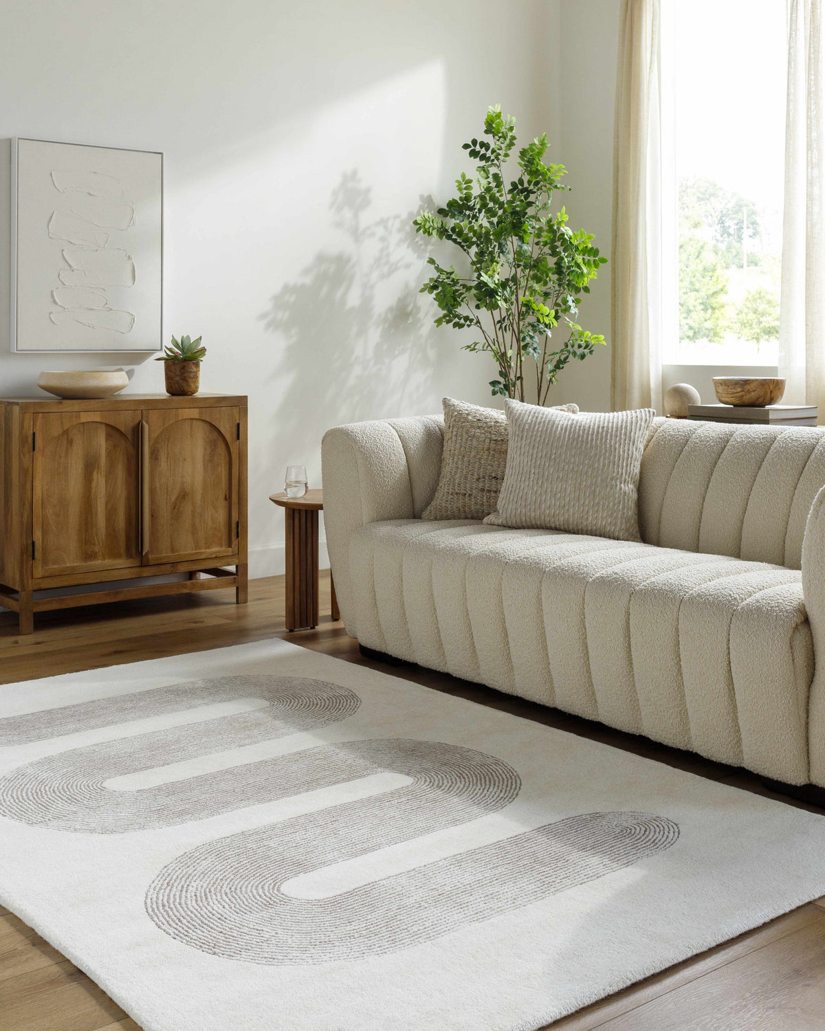 Saura Area Rug by Boutique Rugs, cream textured rug with circular gray swirl pattern on Tampa Home & Garden Store