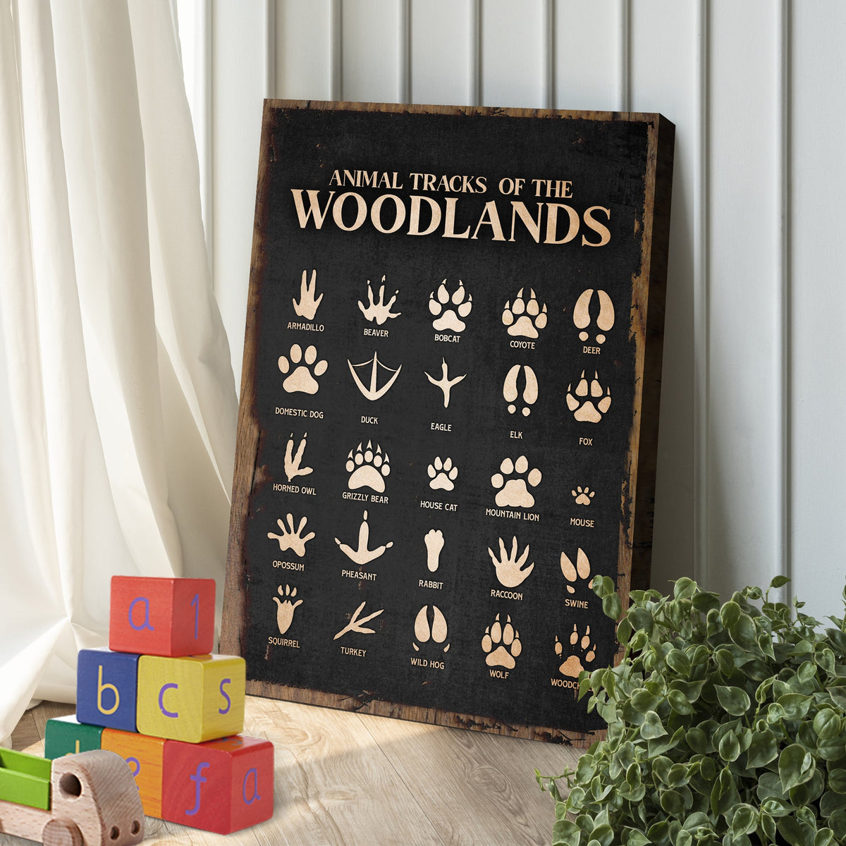 Animal Tracks Of The Woodlands Sign II canvas featuring beige animal track icons on a black surface on Tampa Home & Garden Store