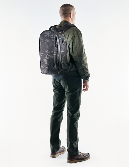 Conceal Pack 21L backpack in gray camouflage by The Brown Buffalo, worn by a man in olive jacket on Tampa Home & Garden Store