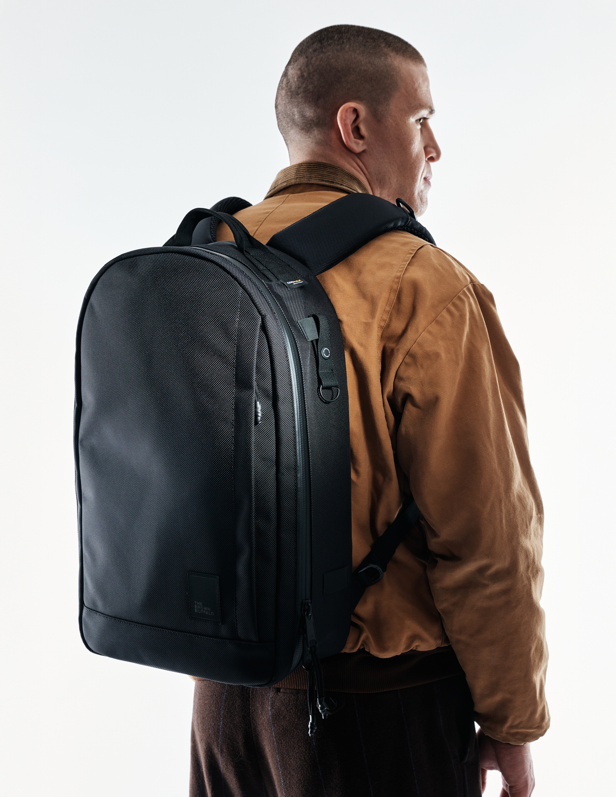 Conceal Pack 21L backpack by The Brown Buffalo, black rugged carryall worn with jacket on Tampa Home & Garden Store