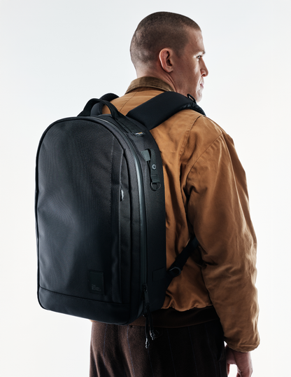 Conceal Pack 21L backpack by The Brown Buffalo, black rugged carryall worn with jacket on Tampa Home & Garden Store