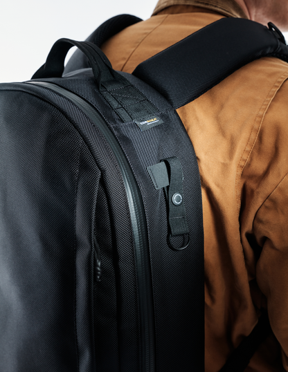Conceal Pack 21L backpack black Cordura fabric with padded straps worn with brown jacket on Tampa Home & Garden Store