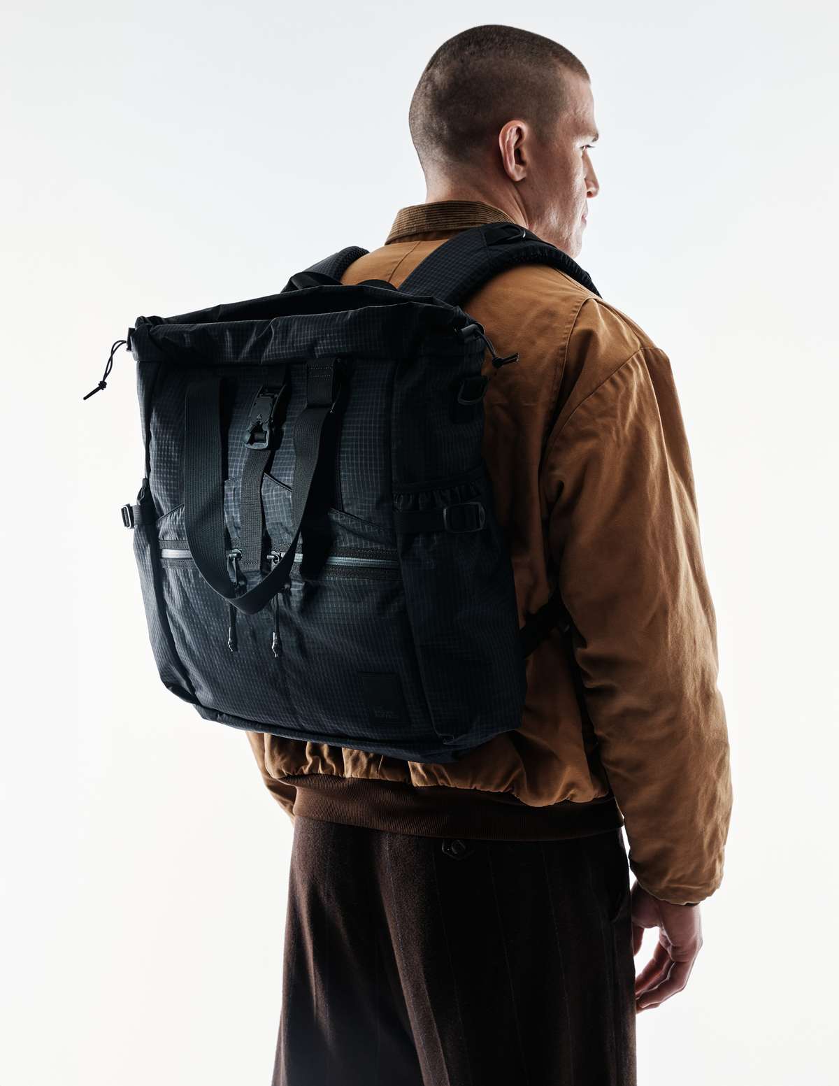 Conceal Tote black tactical tote bag worn on back by brown jacket The Brown Buffalo on Tampa Home & Garden Store