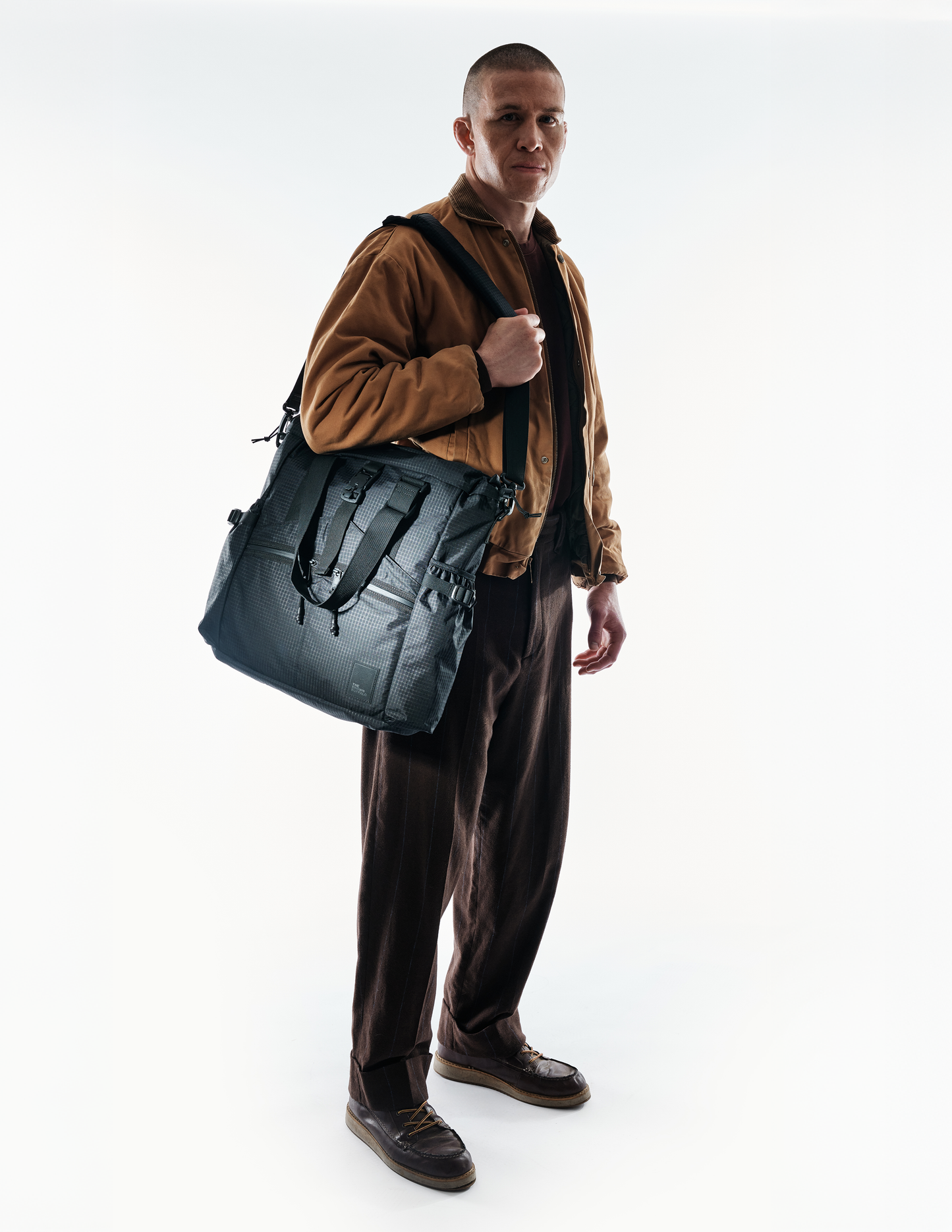 Conceal Tote The Brown Buffalo gray tactical tote with shoulder strap on model on Tampa Home & Garden Store